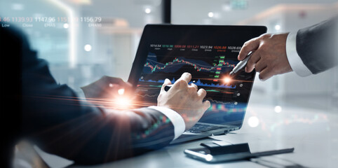Business team working together. Businessman using laptop for analyzing data stock market graph with team pointing on the data presented in the chart, Stock trading, Strategy, Financial investment - obrazy, fototapety, plakaty