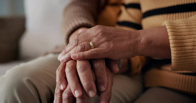 Senior, couple and hands for empathy on sofa with support, grief and comfort in living room of house. Old people, man and woman with love and embrace for security, compassion and sympathy on couch