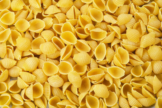 Raw Pasta Conchiglie, textured background
