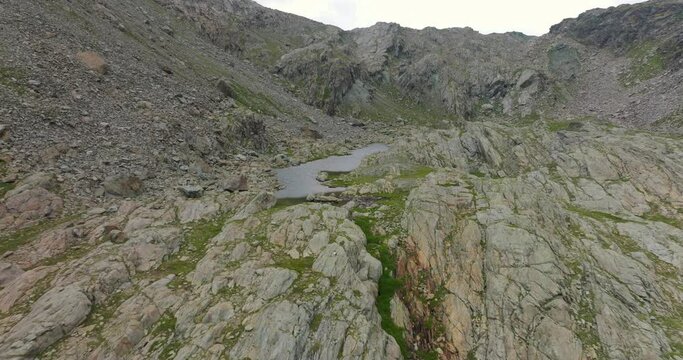 Birdseye view of mountain lake in summer season at Campagneda in Valmalenco of Valtellina region in Italy. Aerial drone