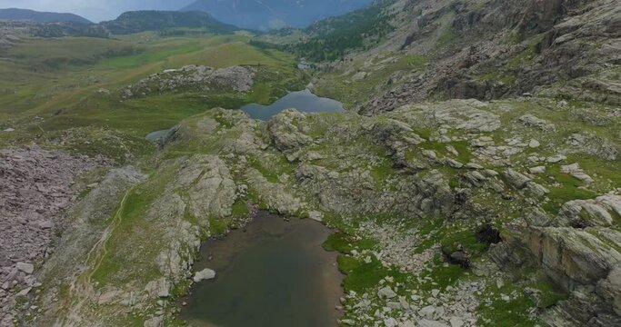 Rocky landscape and mountain lake in summer season at Campagneda of Valmalenco in Italy. Aerial drone view