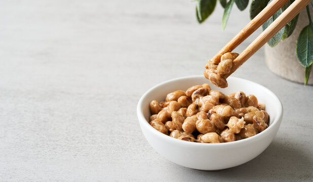natto or fermented soybean in bowl and chopsticks on table white background. natto or fermented soybean Japanese food. natto ferment soybean white background