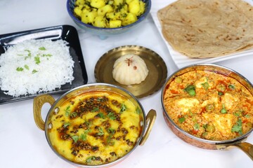 Indian vegetarian Thali or platter includes Aloo ki sabji, dal rice, Roti bhaji, Matar Paneer, Sheera or suji ka halwa, chapati. Indian food is served in a Silver plate or thali. Copy Space. Veg Thali