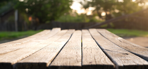 Wooden board empty table in front of blurred background. Perspective brown wood over blur trees in...