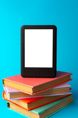 Modern e-book on stack of hardcover books on blue background