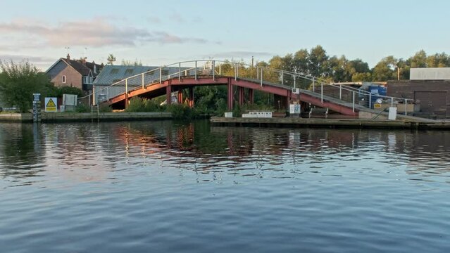 Bridge over the River Bure illuminated by the morning sunshine in the village of Wroxham in the Norfolk Broads