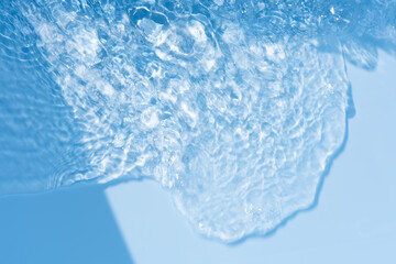 Defocus blurred transparent blue colored clear calm water surface texture with splashes reflection. Trendy abstract nature background. Water waves in sunlight with copy space. Blue watercolor shine.