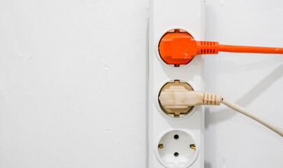 electrical outlet on a wall, electrical power switch, electric plug on a wall, orange electrical plug