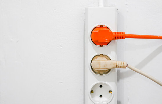 electrical outlet on a wall, electrical power switch, electric plug on a wall, orange electrical plug