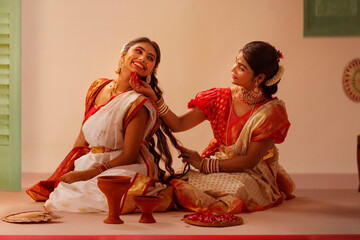 Mother and daughter doing preparation at home on the occasion of Durga Puja 