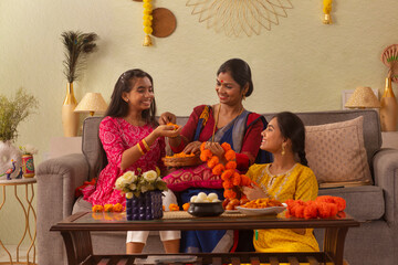 Bengali family making flower garland at home on the occasion of Durga Puja
