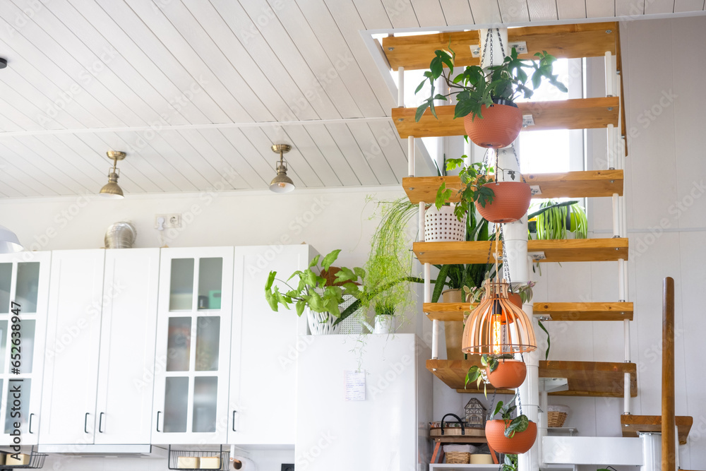 Wall mural modular metal staircase with wooden steps in the white interior of a green house with potted plants,