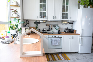 Light white modern rustic kitchen decorated with potted plants, loft-style kitchen utensils....