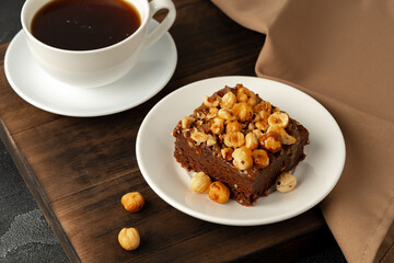 Brownie cake with nuts topping on plate close up