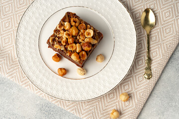 Brownie cake with nuts topping on plate close up