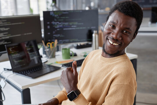 Portrait of African American successful programmer smiling at camera and showing thumb up