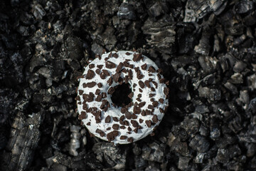 White donut (doughnut ) in black charcoal
