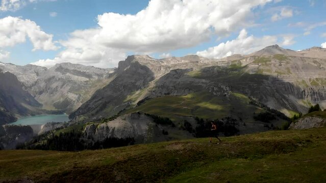4K drone footage over woman hiking in the Swiss Alps with huge mountain landscape on the back, Switzerland.
Mid angle, parallax movement.
