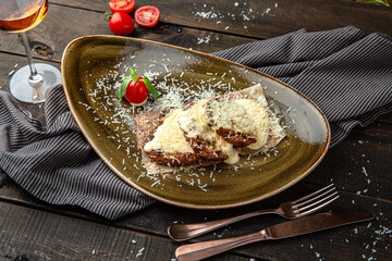 Veal medallions in cheese sauce. Menu for a restaurant. Beautiful composition on wooden boards.
