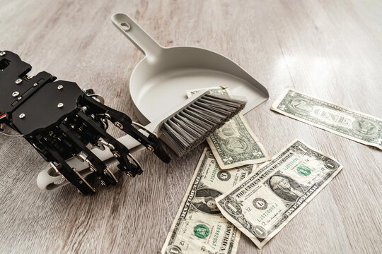Robotic hand wielding a dustpan and brush, meticulously sweeping up one-dollar bills