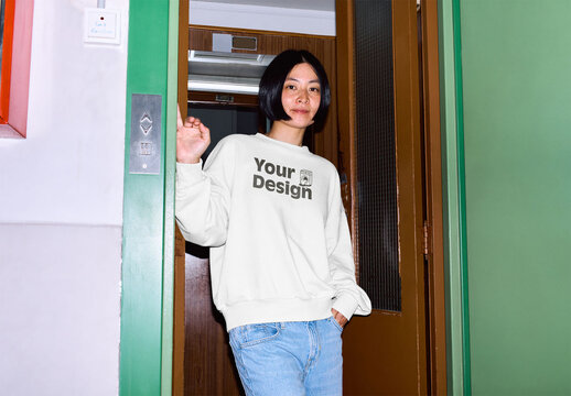 Mockup of Asian woman wearing sweatshirt with customizable color in elevator doorway, camera flash