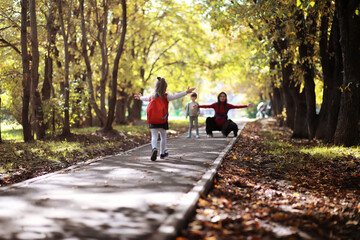 Obraz premium Children with briefcases for a walk in the park. School break. The beginning of the children's studies.