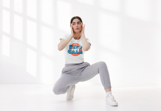 Mockup of woman wearing t-shirt with customizable color and design crouching on floor