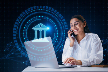 Attractive happy young european businesswoman using laptop and cellphone with creative round polygonal banking hologram on blurry background. Digital transformation and finance concept.