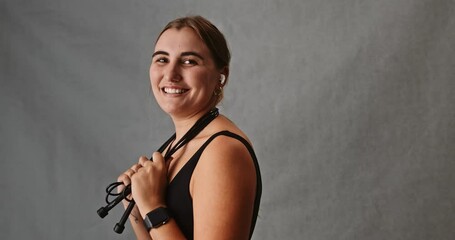 Young woman placing her skipping rope around her neck - Powered by Adobe