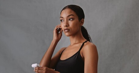 African fitness woman getting ready for workout putting earphones in