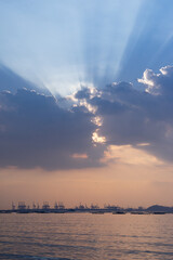 huge white sun-rays behind cloud, calm peach pink blue sky 