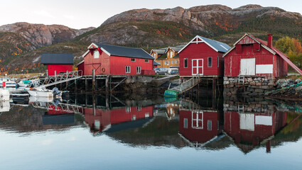 Norwegian landscape with traditional old red wooden barns on the sea coast