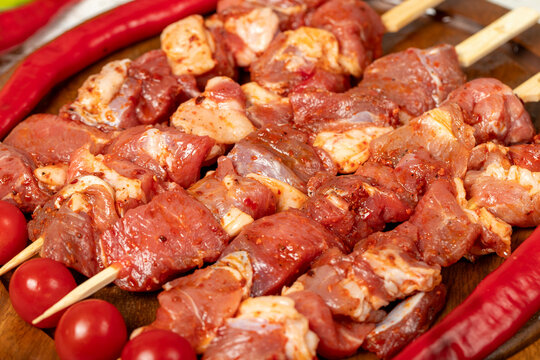 Lamb skewers on wood background. Raw lamb skewer with herbs and spices. Local name kuzu kusleme. Close up
