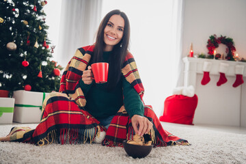 Photo of pretty adorable lady dressed knitted x-mas sweater drinking tea eating snacks indoors...