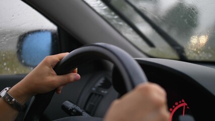 Car Dashboard and Female Hands Holding Steering Wheel When Driving in Heavy Rain