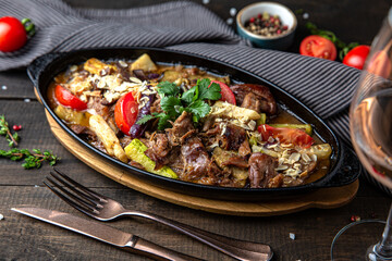 Roast lamb with vegetables. Lamb fillet, eggplant, zucchini, tomato and greens. Menu for a restaurant. Beautiful composition on wooden boards.