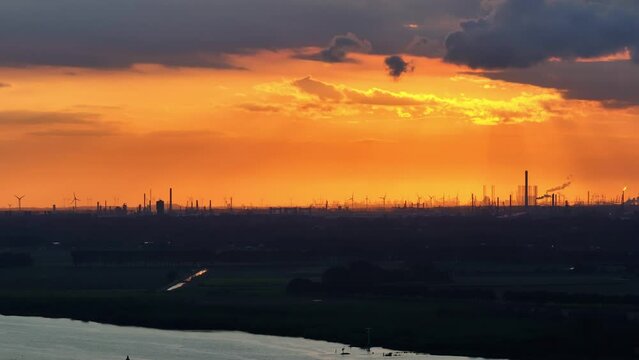 A very orange and dark sunset over Barendrecht and the Oude Maas river