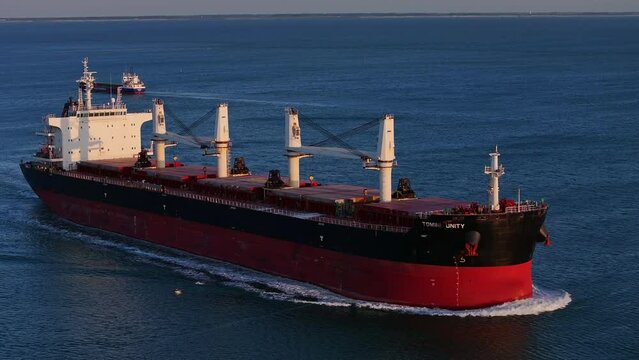 Aerial view of the red Tomini Unity ship sailing on the sea at sunset
