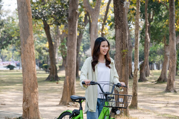 Fototapeta na wymiar Happy woman riding bicycle at park.