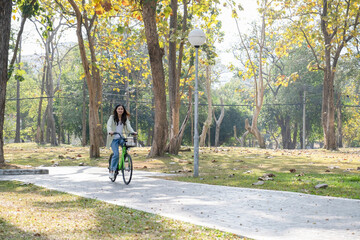 Happy woman riding bicycle at park.