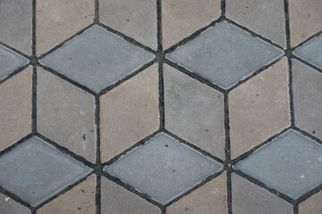Closeup of ornamental pavement made of brown and grey concrete blocks