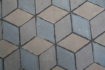 Old ornamental pavement made of brown and grey concrete blocks