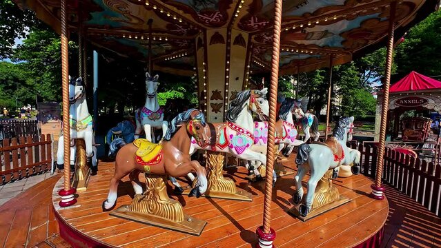 Colourful Merry Go Round Horse Carousel at an Outdoor Fun Park in Slow Motion