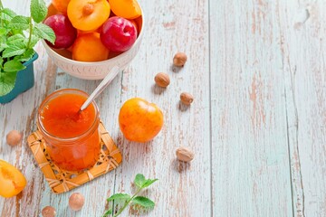 Fresh Plums and Jar of Jam on Wooden Table