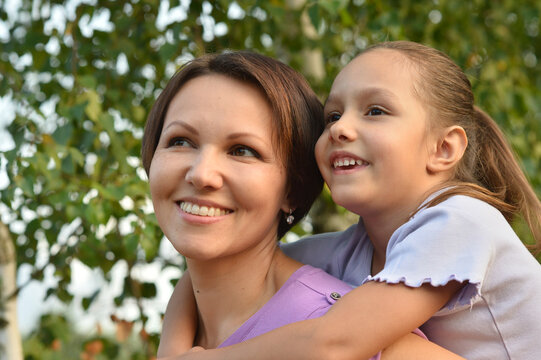 Close up portrait of happy mother and daughter smiling outdoors