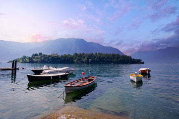 Fototapeta na wymiar Beautiful scene of boats on lake Como in Italy. A big blue lake surrounded by green hills