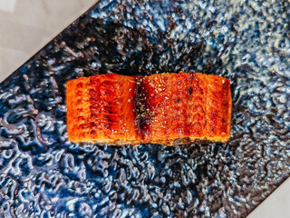 Eel rice sushi is on a plate ready to eat. "Unagi Sushi" is a popular type of sushi in Japanese cuisine. The eel is often cooked until it becomes tender and slightly crispy on the outside by grilling.