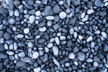 Fototapeta na wymiar Gray pebbles as a background. Round stones on the beach. Photography for design. Textures in nature.
