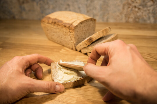 buttering a slice of fresh homemade bread