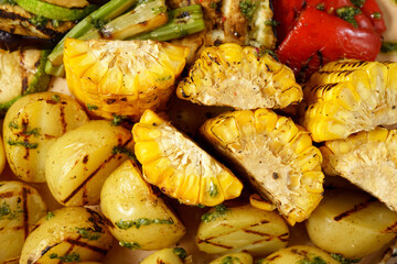 Baked potatoes, corn, lie on a large frying pan. Food court. Selective focus
